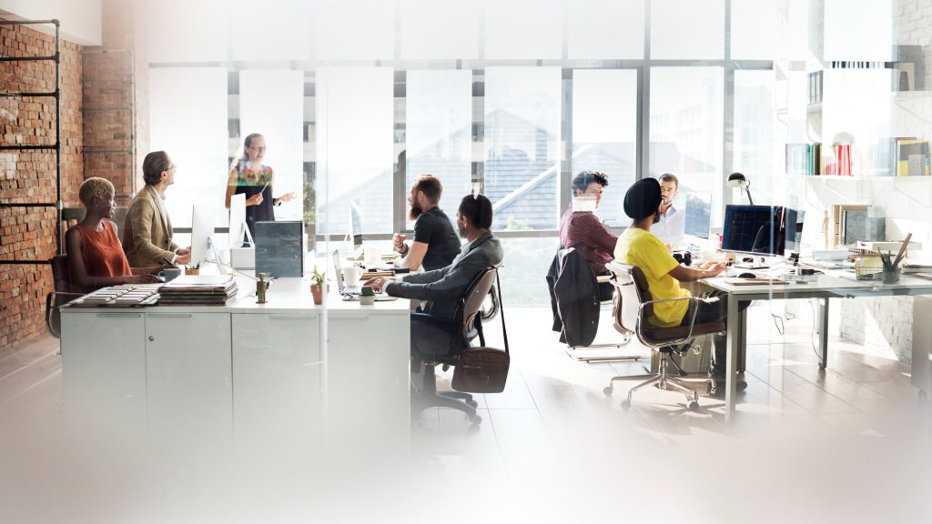Grupo de profesionales trabajando en sus escritorios dentro de una oficina corporativa moderna