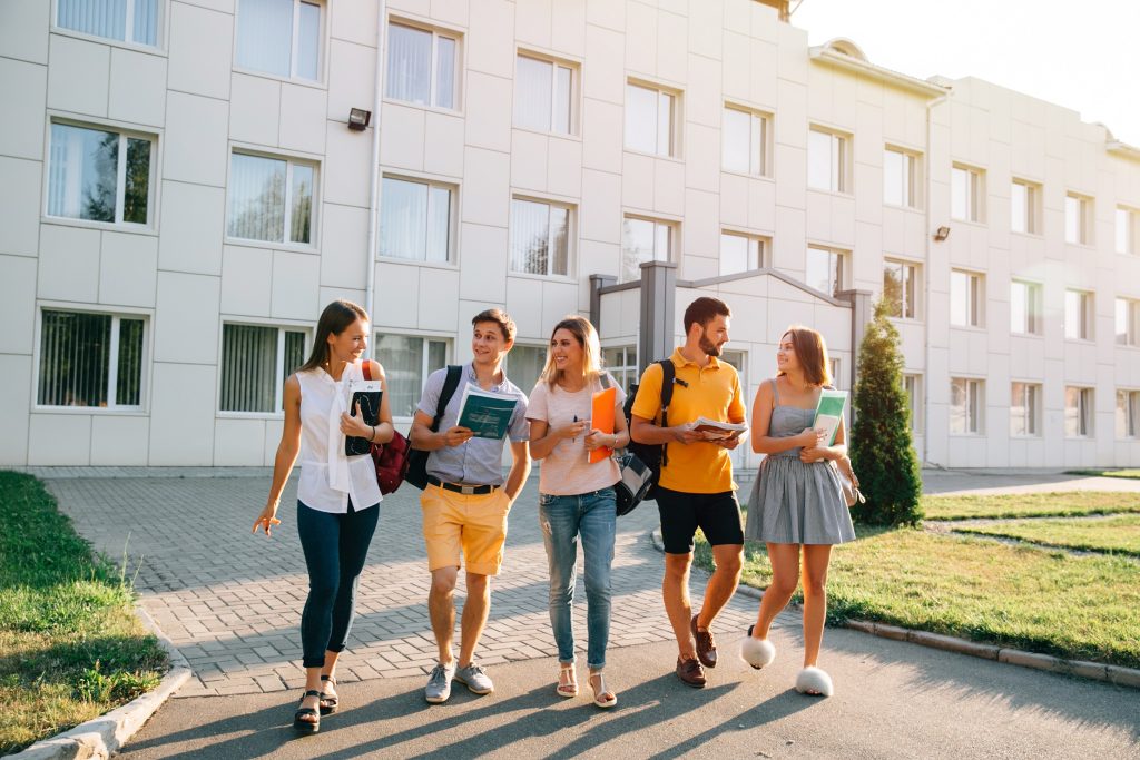 Estudiantes universitarios saliendo de una residencia listos para comenzar el año académico